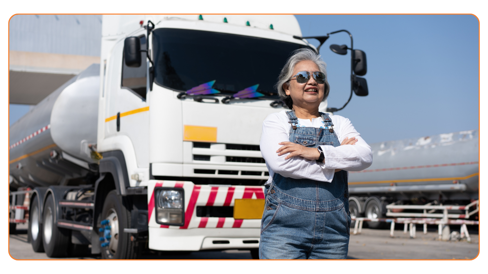 A professional standing next to a white commercial tanker truck, suggesting an FMCSA vehicle inspection is underway.